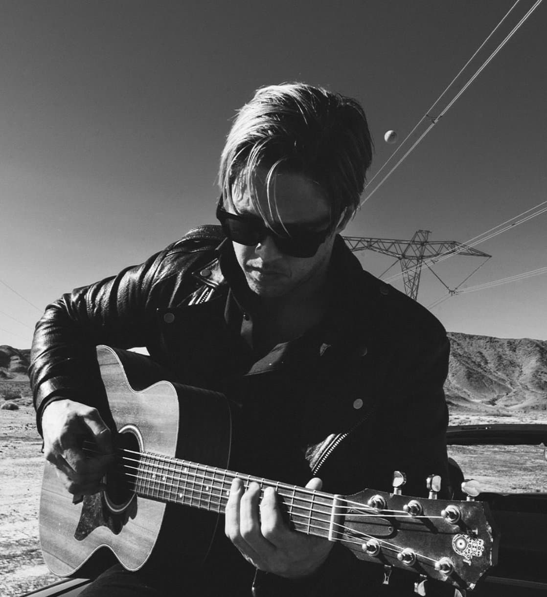 Acoustic guitar in the desert, power lines overhead